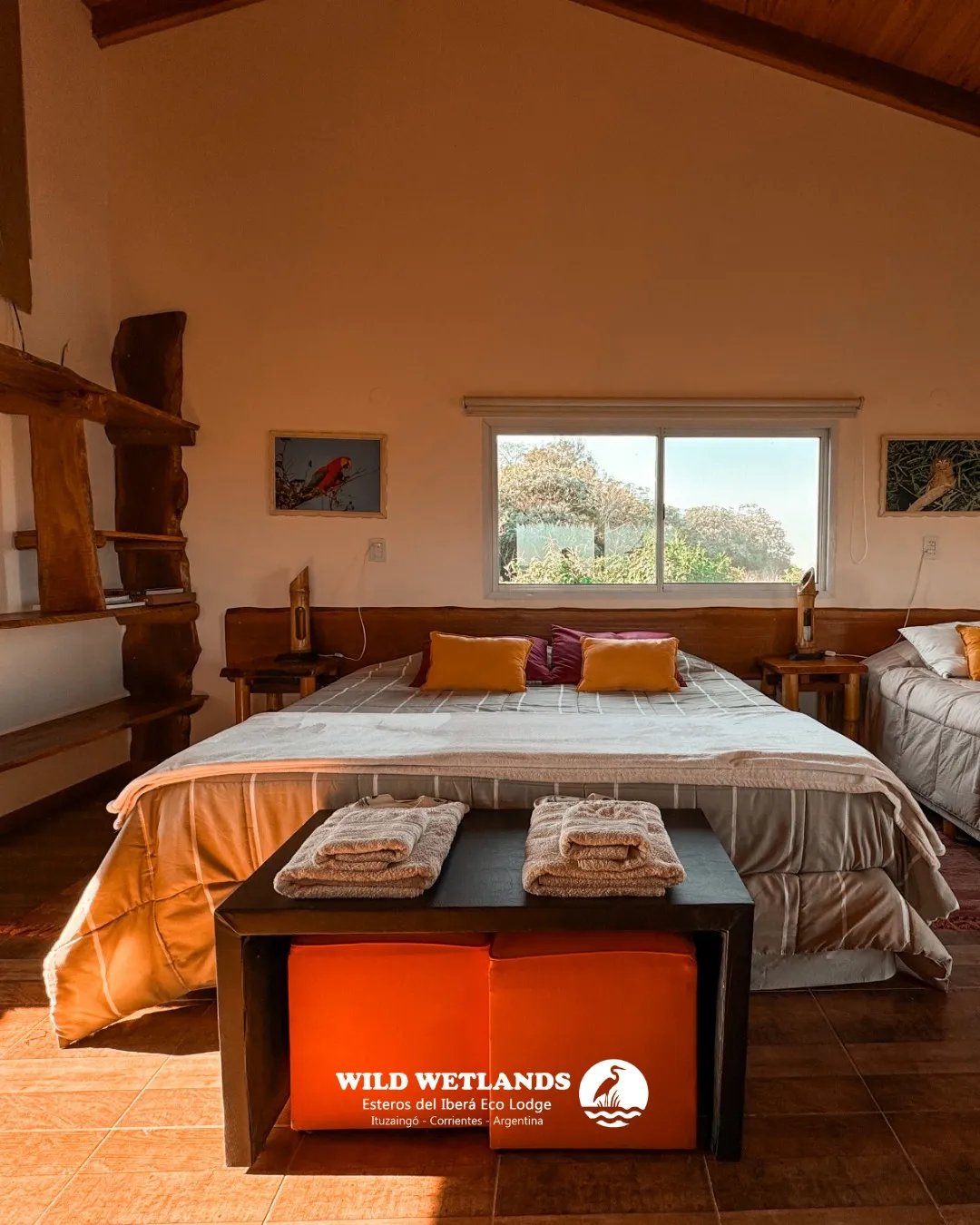 Interior de la habitación suite con cama matrimonial y vistas a la reserva